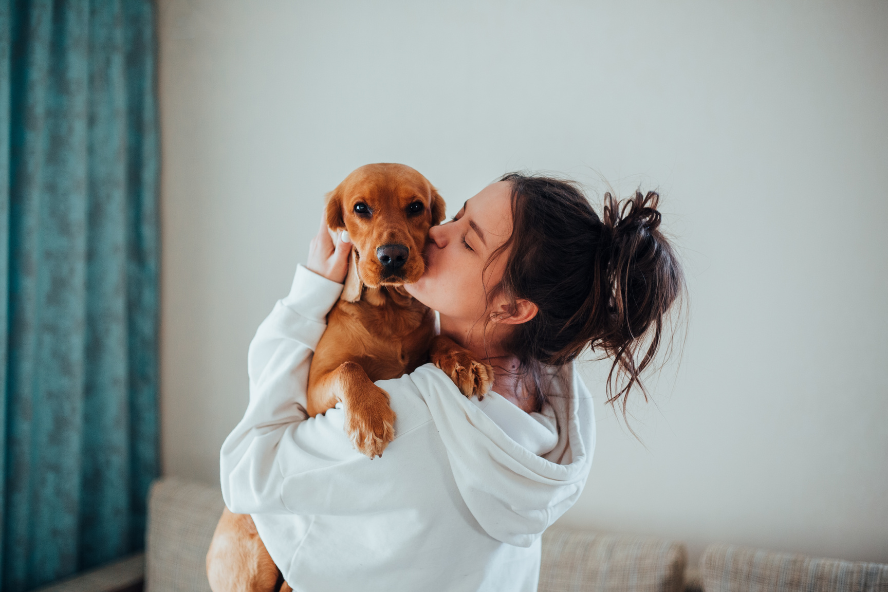 Loving woman kissing and cuddling cute dog